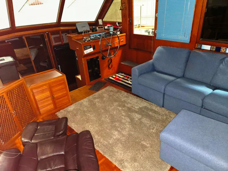 Slide: The Image of 1989 Marine Trader 47 CMY interior with helm, blue sofa, and brown recliner. - 13