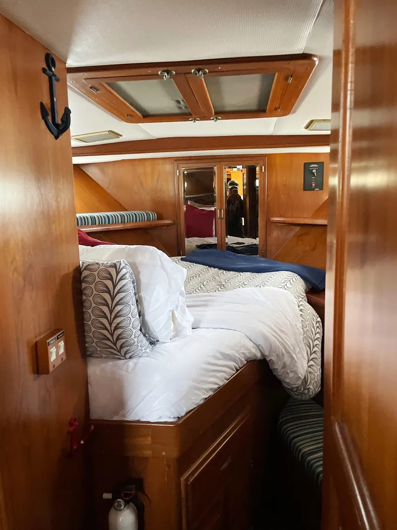 Slide: The Image of Cozy cabin interior of 1989 Marine Trader 47 CMY with wood paneling and bedding. - 17