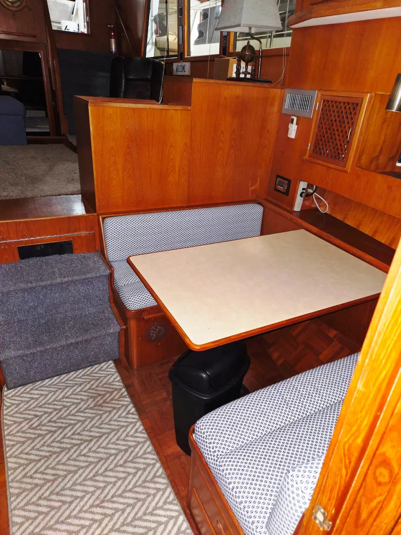 Slide: The Image of 1989 Marine Trader 47 CMY interior with cozy dining area and wooden finish. - 19