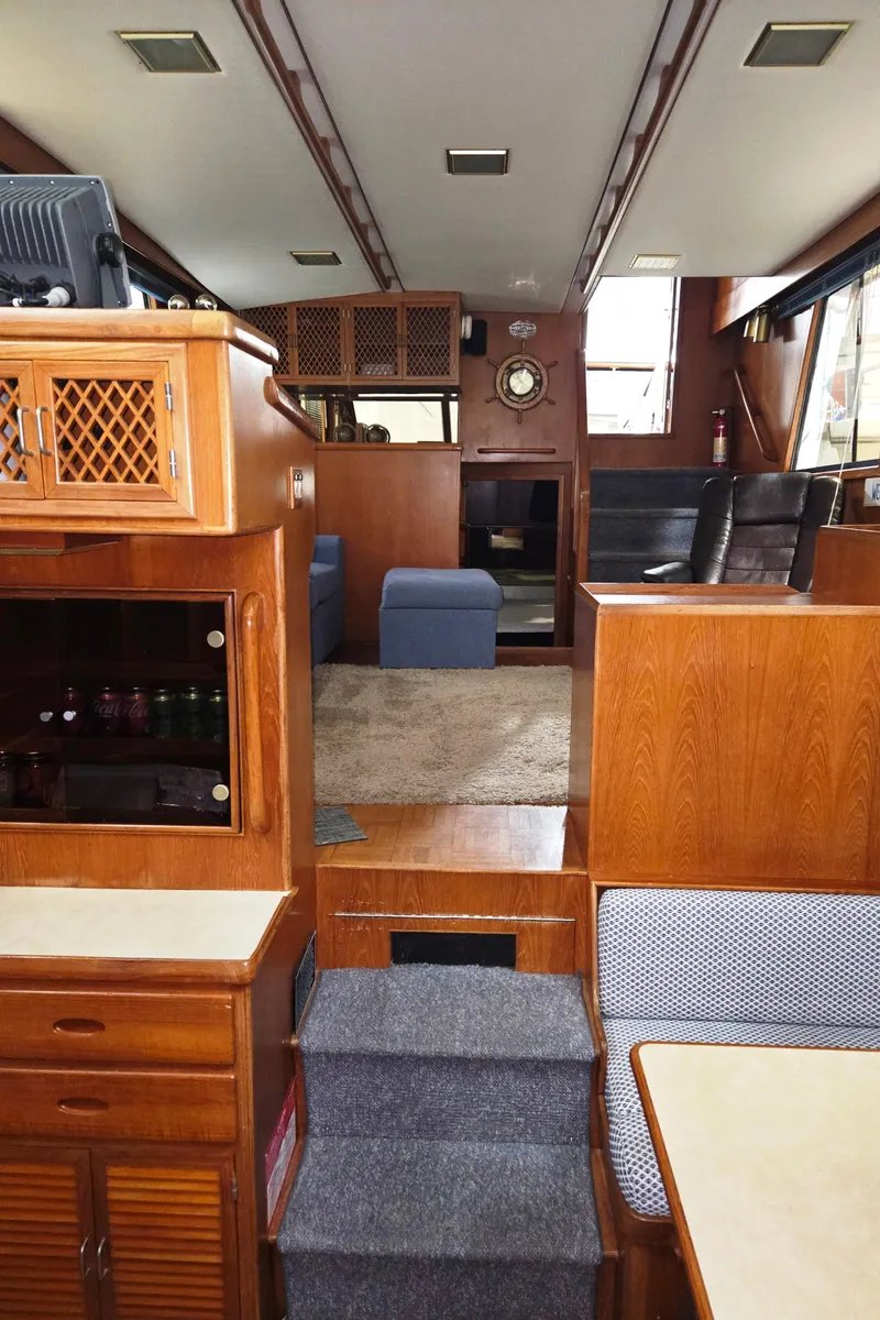 Slide: The Image of Interior of 1989 Marine Trader 47 CMY yacht, featuring wood cabinetry and carpeted steps. - 21
