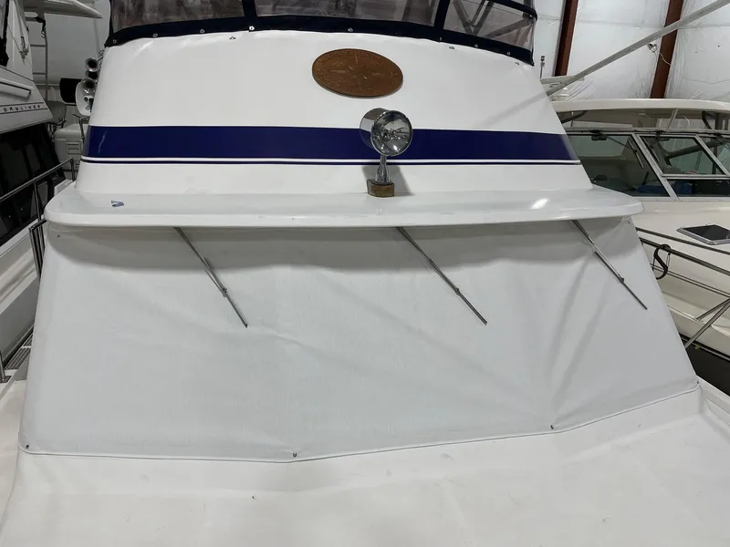 Slide: The Image of 1989 Marine Trader 47 CMY yacht with blue stripe and spotlight, docked indoors. - 3