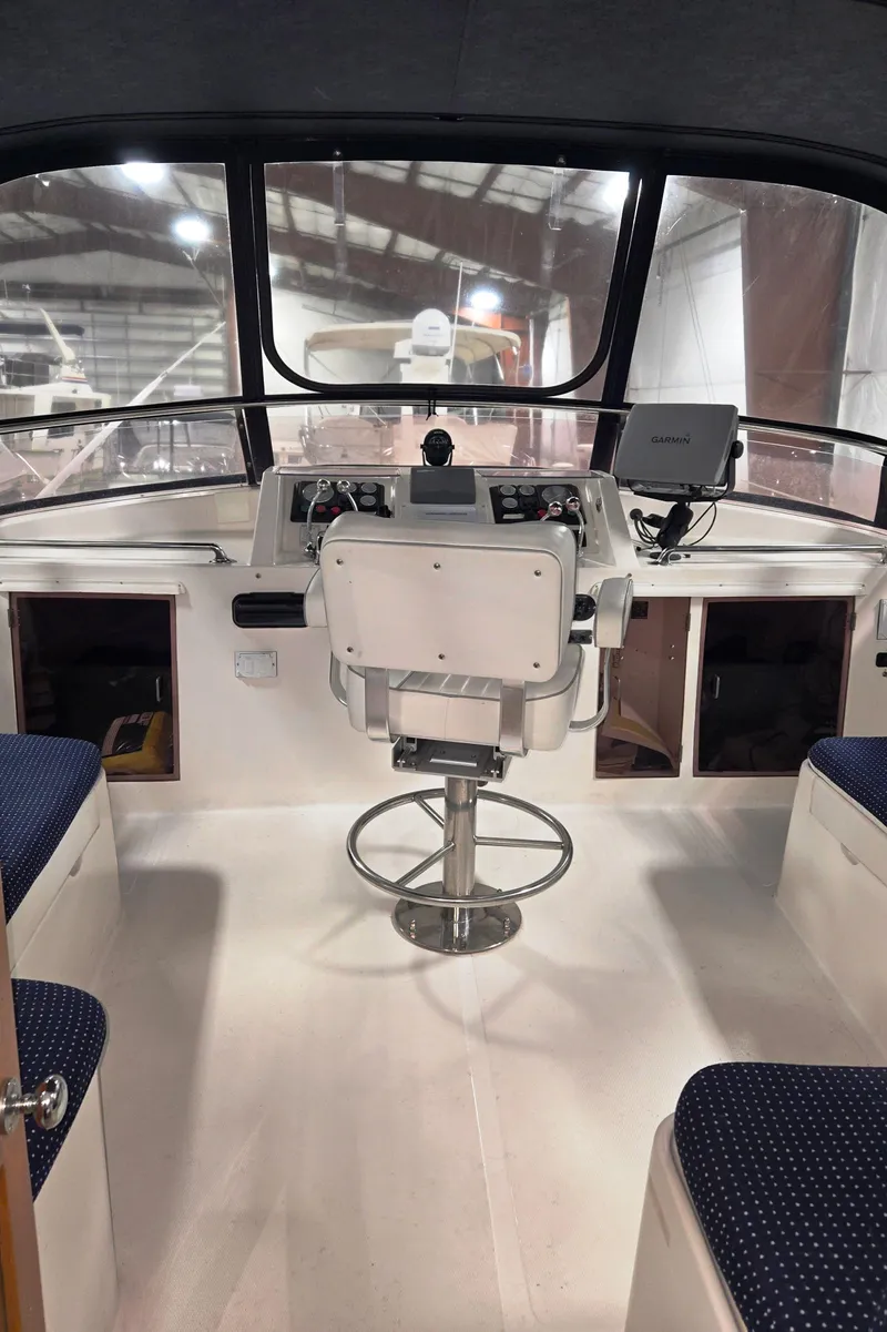 Slide: The Image of 1989 Marine Trader 47 CMY helm with seating, steering wheel, and navigation equipment. - 5