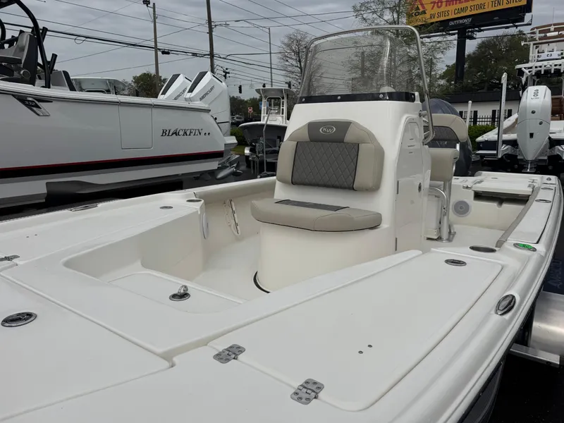 Slide: The Image of 2025 Key West 210 Bay Reef boat with seating and console, displayed outdoors. - 14