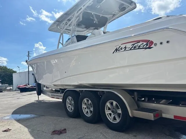 Slide: The Image of 2019 Nor-Tech 340 Sport Center Console boat on trailer under blue sky. - 13