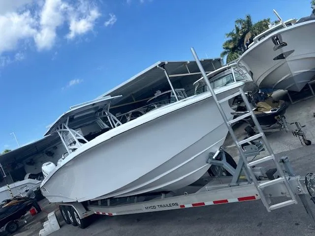 Slide: The Image of 2019 Nor-Tech 340 Sport Center Console boat on trailer, parked outdoors under blue sky. - 14