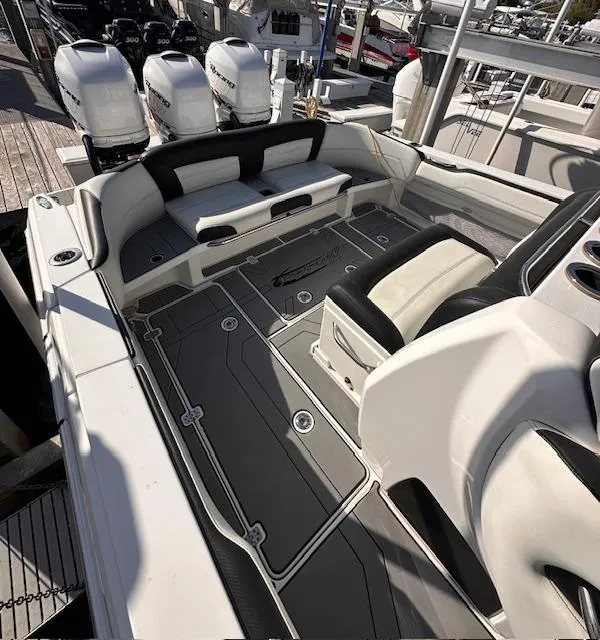Slide: The Image of 2019 Nor-Tech 340 Sport Center Console boat interior with seating and triple engines. - 2
