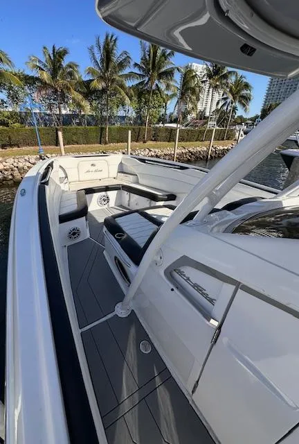 Slide: The Image of 2019 Nor-Tech 340 Sport Center Console boat docked by palm trees. - 6