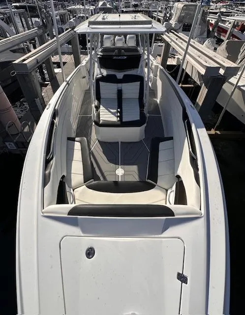 Slide: The Image of 2019 Nor-Tech 340 Sport Center Console boat docked, featuring sleek design and spacious seating. - 7