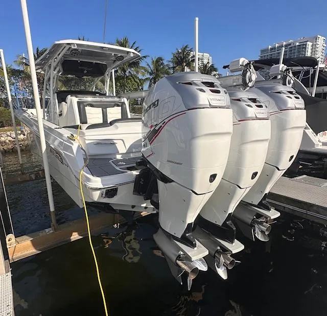 Slide: The Image of 2019 Nor-Tech 340 Sport Center Console boat with triple outboard engines docked. - 9