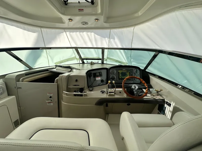 Slide: The Image of 2007 Sea Ray 380 Sundancer helm with leather seats and modern navigation controls. - 13
