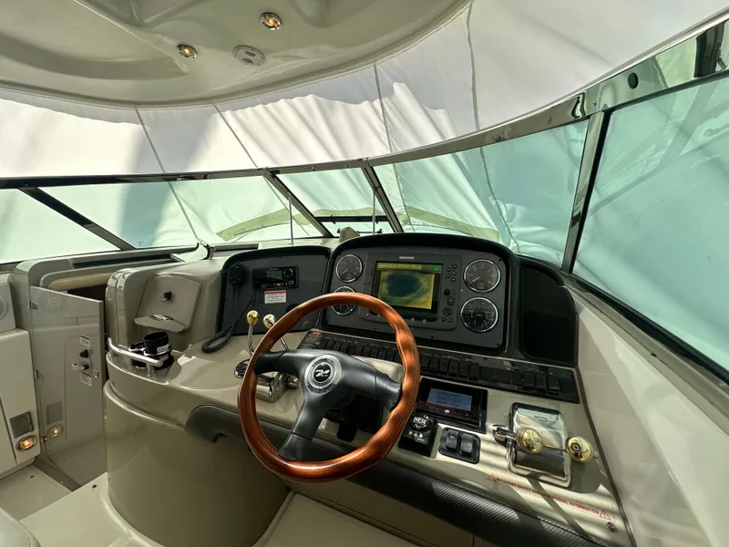 Slide: The Image of 2007 Sea Ray 380 Sundancer helm with wood steering wheel and modern navigation controls. - 16