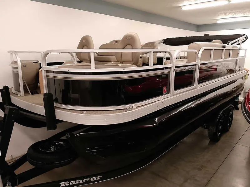 The Image of 2023 Ranger Reata 200F Pontoon boat in showroom, featuring sleek design and comfortable seating. - 1