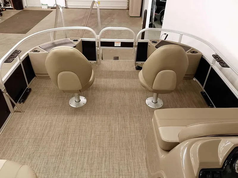 Slide: The Image of 2023 Ranger Reata 200F Pontoon interior with beige seating and carpeted flooring. - 21