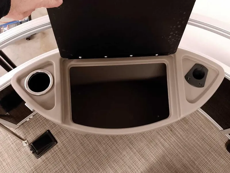 Slide: The Image of 2023 Ranger Reata 200F Pontoon storage compartment with cup holder and accessory slot. - 24