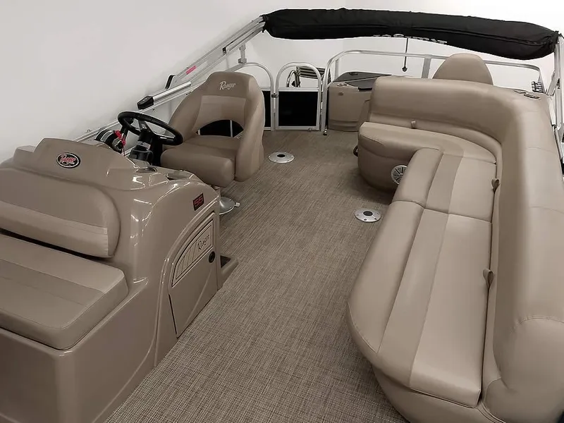 Slide: The Image of 2023 Ranger Reata 200F Pontoon interior with beige seating and steering console. - 8