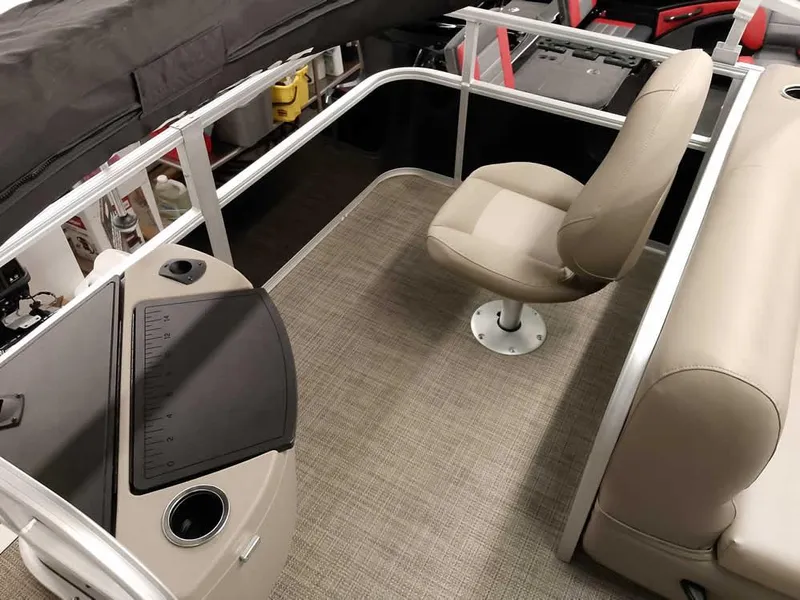 Slide: The Image of 2023 Ranger Reata 200F Pontoon interior with beige seating and control panel. - 9
