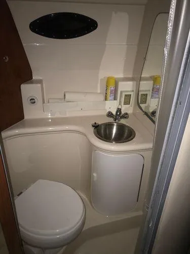 Slide: The Image of 2010 Regal 2700 Commodore boat bathroom with sink, toilet, and mirror. - 11