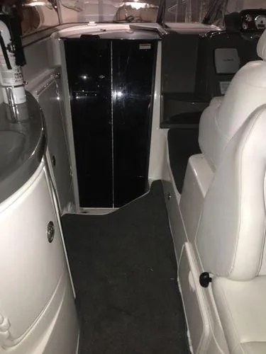 Slide: The Image of 2010 Regal 2700 Commodore boat interior with white seating and black cabinet. - 13