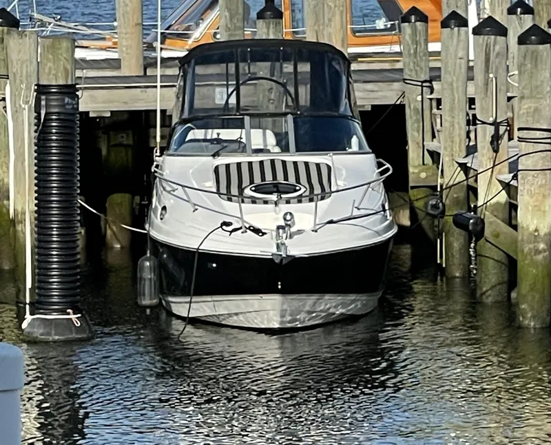 Slide: The Image of 2010 Regal 2700 Commodore boat docked at a marina. - 2