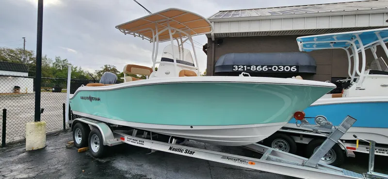 The Image of 2025 NauticStar 212 Legacy boat on trailer, light blue hull, parked outdoors. - 0