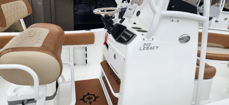 Slide: The Image of 2025 NauticStar 212 Legacy boat interior with tan seating and steering console. - 4