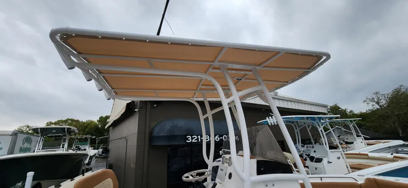 Slide: The Image of 2025 NauticStar 212 Legacy boat with T-top canopy, displayed outdoors. - 6