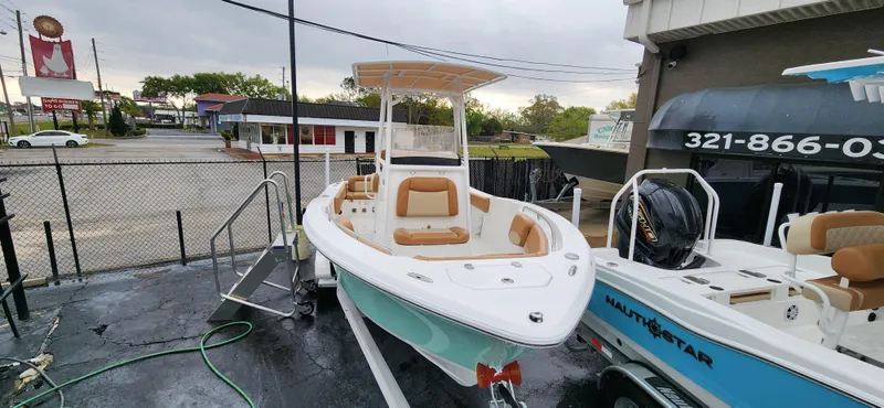 Slide: The Image of 2025 NauticStar 212 Legacy boat displayed outdoors, featuring sleek design and modern amenities. - 8