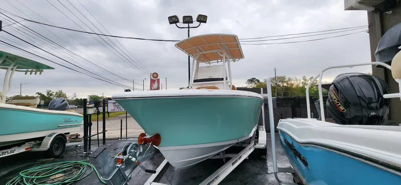 Slide: The Image of 2025 NauticStar 212 Legacy boat on trailer, displayed outdoors under cloudy sky. - 9
