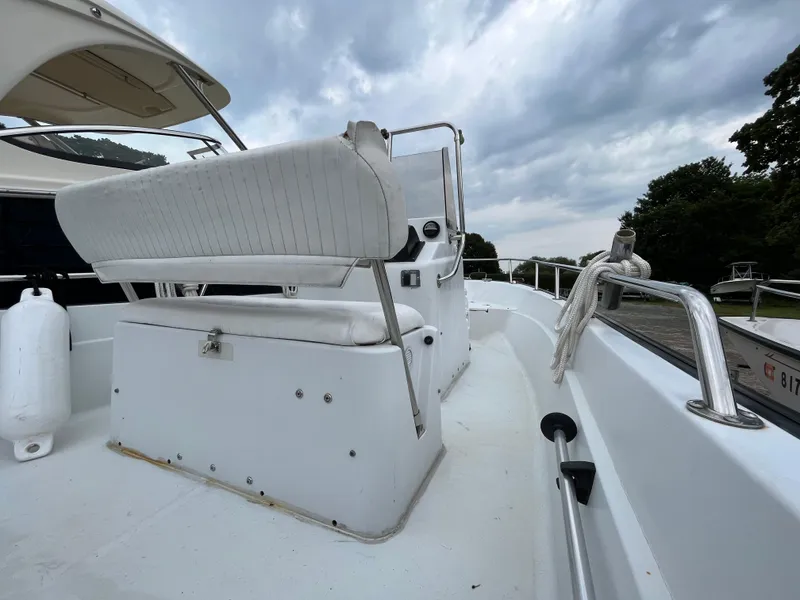 Slide: The Image of 1994 Boston Whaler 15 Dauntless boat interior with white seating and overcast sky. - 10