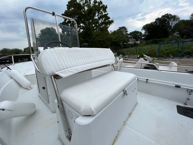 Slide: The Image of 1994 Boston Whaler 15 Dauntless boat with white seating and console, outdoors. - 14