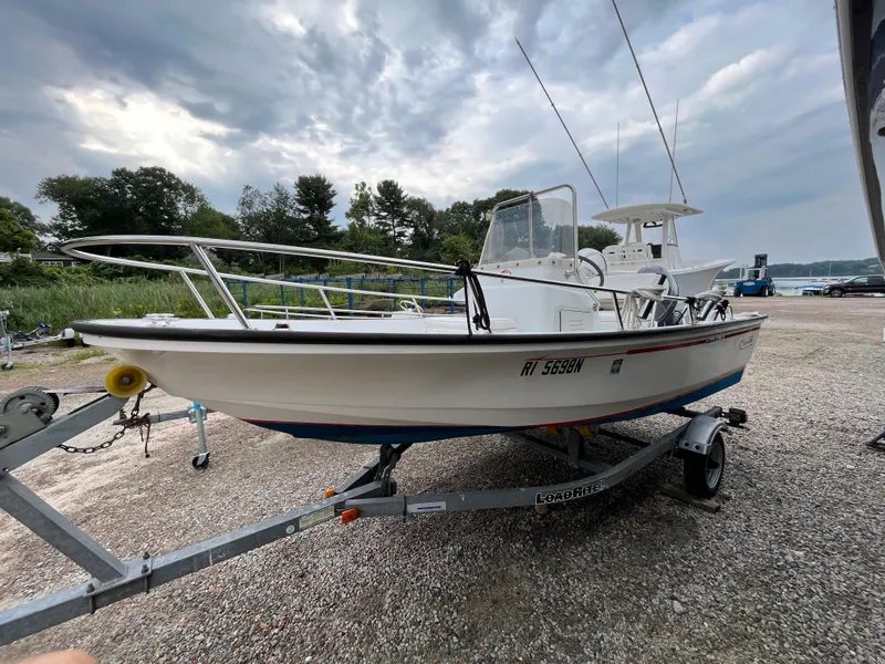 Slide: The Image of 1994 Boston Whaler 15 Dauntless boat on trailer, parked outdoors under cloudy sky. - 3
