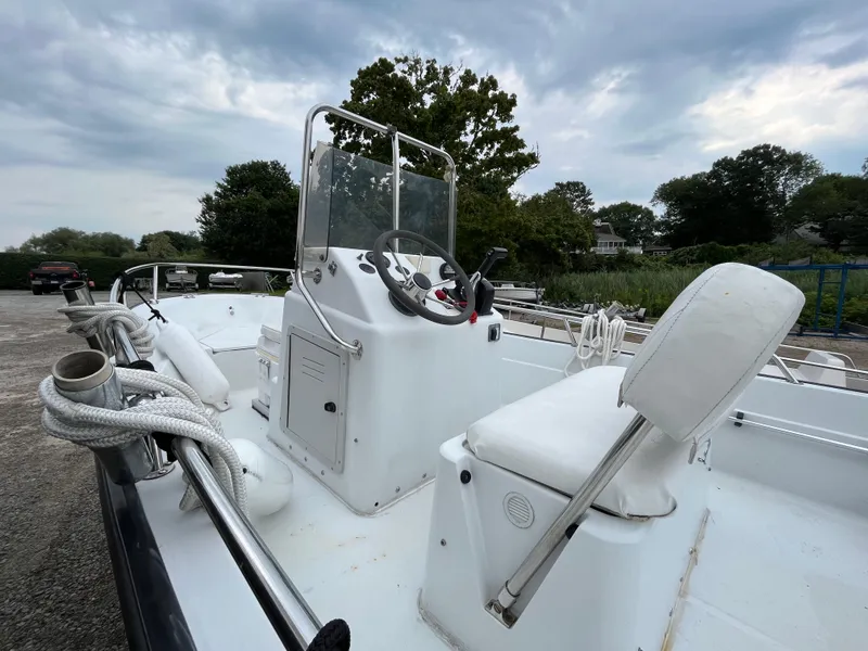 Slide: The Image of 1994 Boston Whaler 15 Dauntless boat with white seating and steering console. - 4