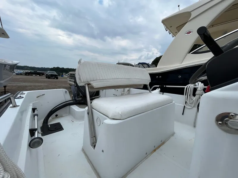 Slide: The Image of 1994 Boston Whaler 15 Dauntless boat interior with white seating and steering console. - 8