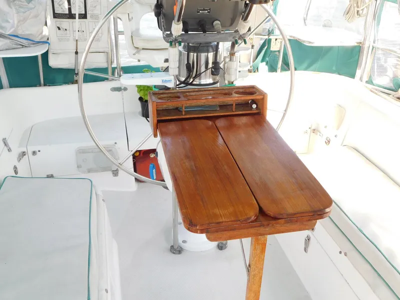 Slide: The Image of 1998 Catalina 34 Mark II cockpit with wooden folding table and steering wheel. - 10