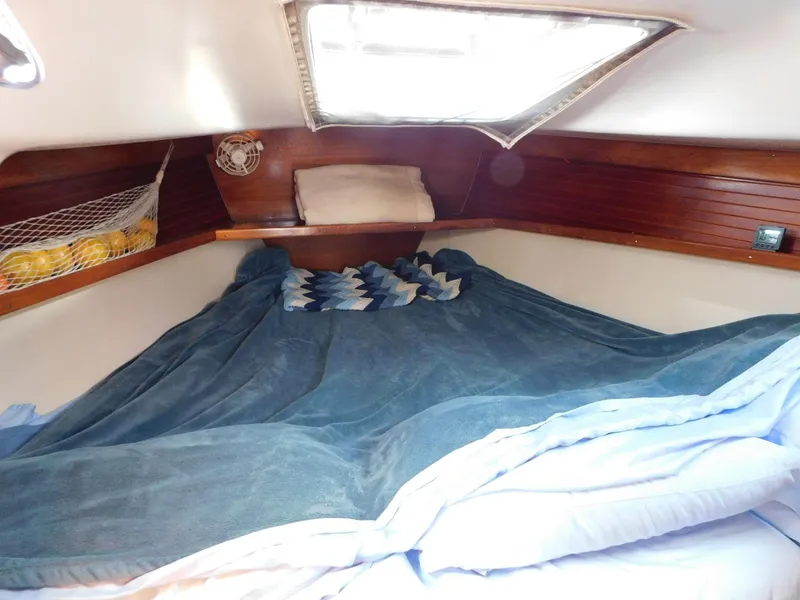 Slide: The Image of Cozy cabin interior of a 1998 Catalina 34 Mark II sailboat with bedding and storage. - 14