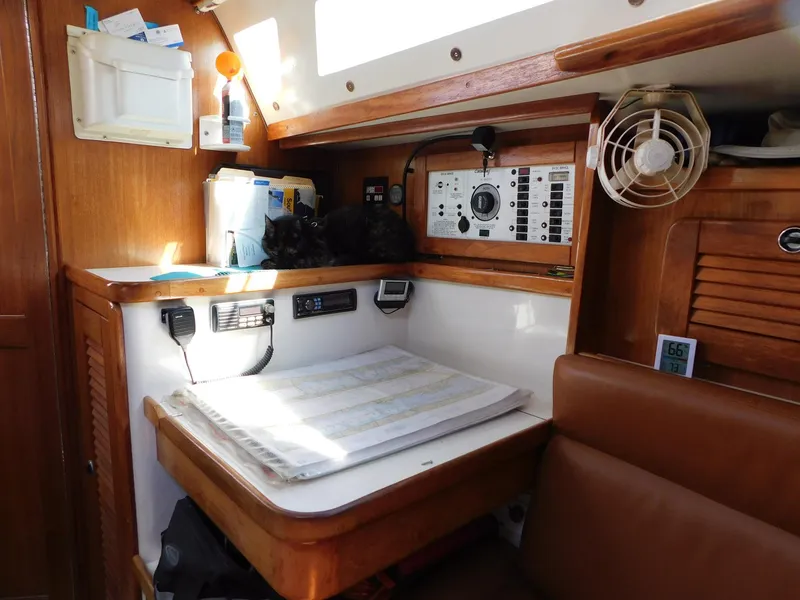 Slide: The Image of Navigation station inside 1998 Catalina 34 Mark II sailboat, featuring charts and control panels. - 17