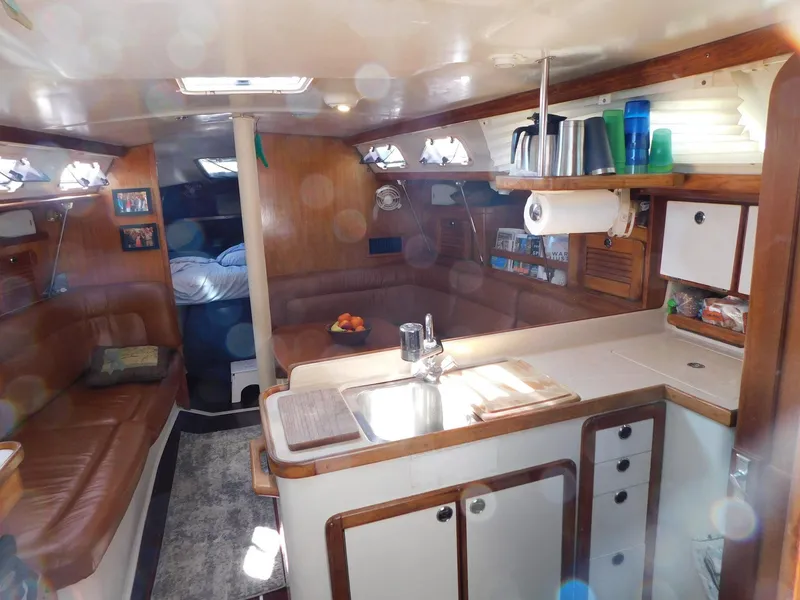 Slide: The Image of Interior of a 1998 Catalina 34 Mark II sailboat with cozy seating and kitchen area. - 20