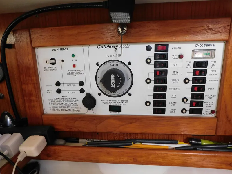 Slide: The Image of Electrical panel of a 1998 Catalina 34 Mark II sailboat, featuring AC and DC service controls. - 23