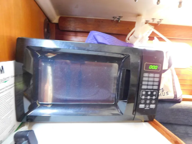 Slide: The Image of Black microwave inside a 1998 Catalina 34 Mark II yacht kitchen area. - 24