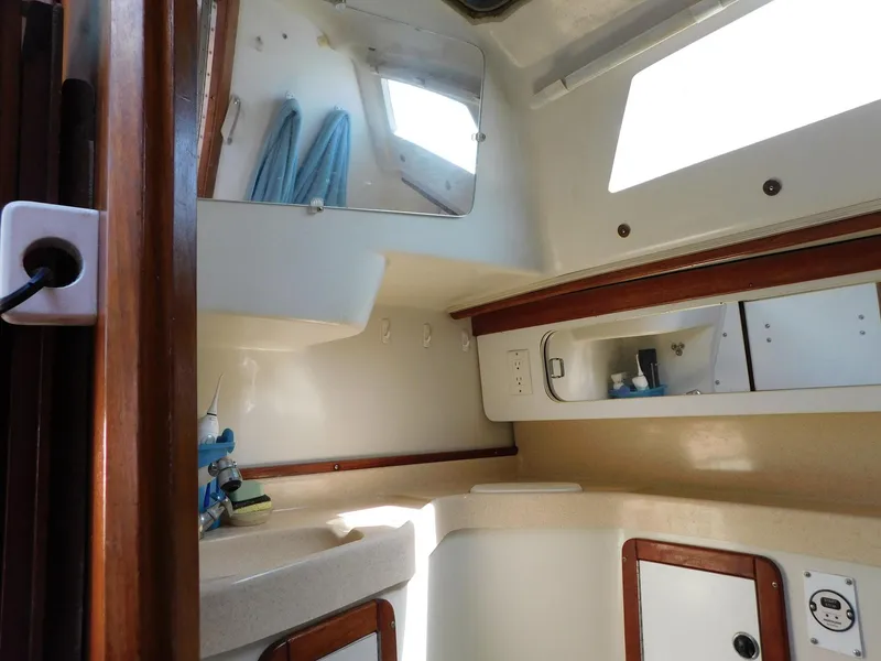 Slide: The Image of Interior of 1998 Catalina 34 Mark II sailboat, featuring compact bathroom with mirror and storage. - 28