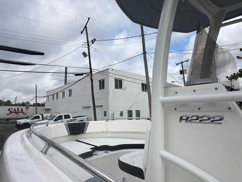 Slide: The Image of 2025 Robalo R222 boat parked near industrial building under cloudy sky. - 13