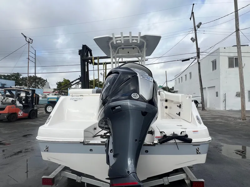 Slide: The Image of 2025 Robalo R222 boat with Yamaha outboard motor, parked in an industrial area. - 21