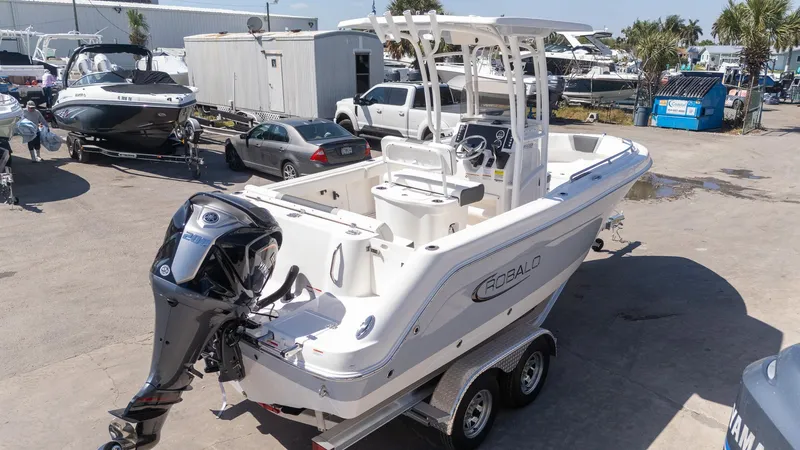 Slide: The Image of 2025 Robalo R222 boat on trailer in marina setting. - 22