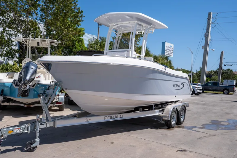 Slide: The Image of 2025 Robalo R222 boat on trailer in outdoor setting, clear sky background. - 4