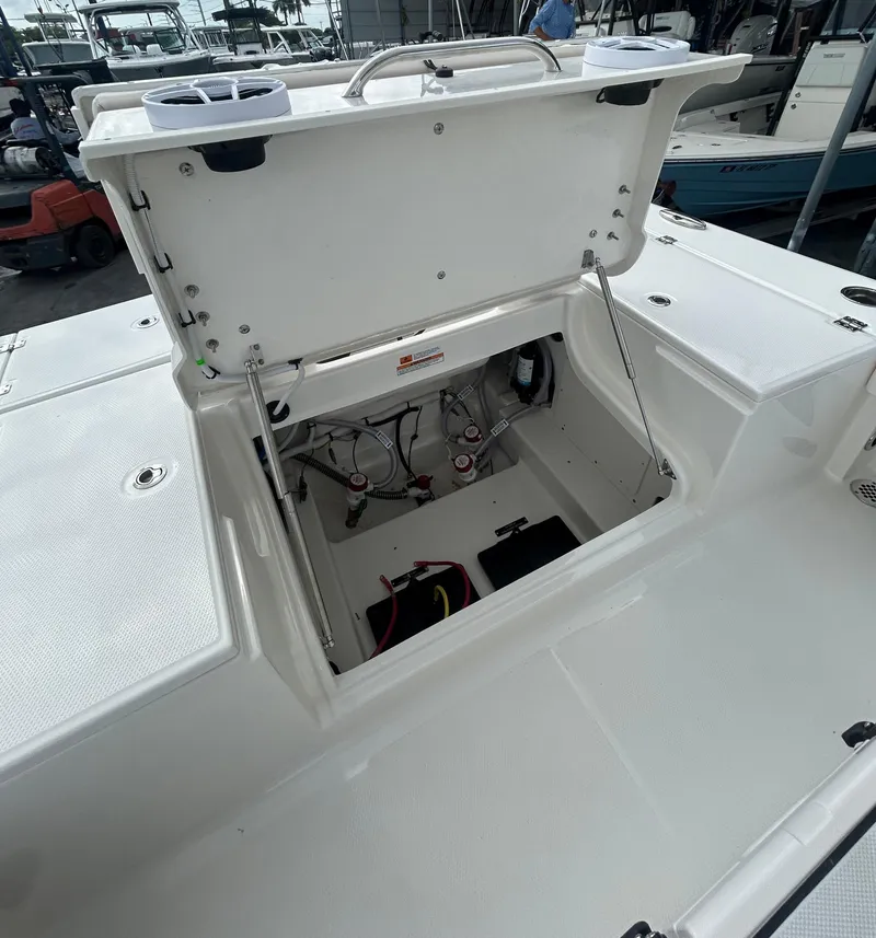 Slide: The Image of 2025 Robalo 246 Cayman boat storage compartment open, revealing interior components. - 11