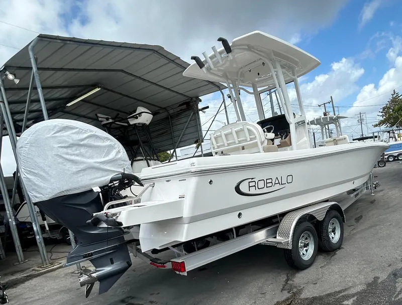 Slide: The Image of 2025 Robalo 246 Cayman boat on trailer under a metal canopy. - 13