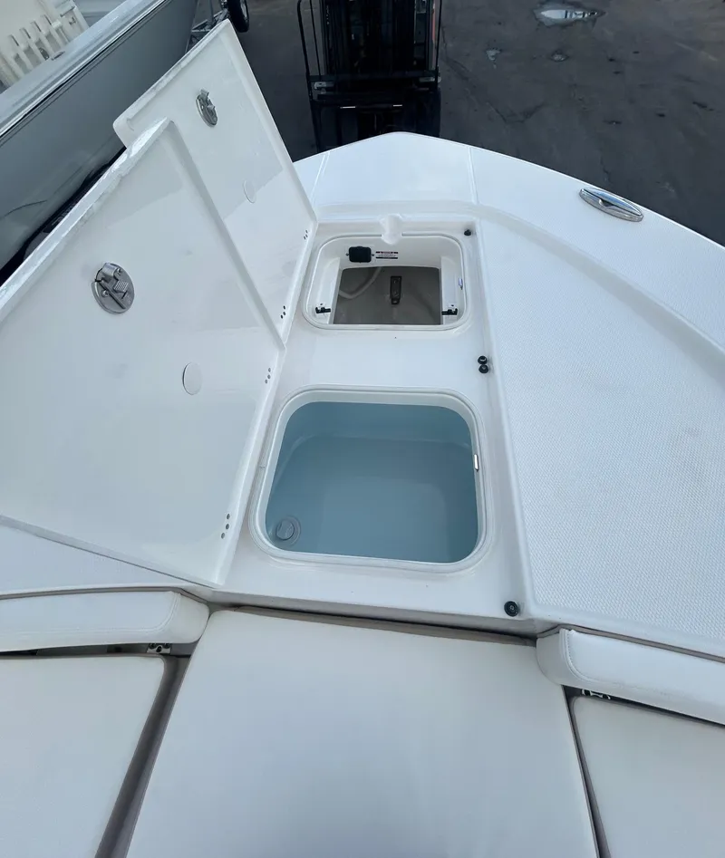 Slide: The Image of 2025 Robalo 246 Cayman boat storage compartments with open lids, showcasing interior features. - 4