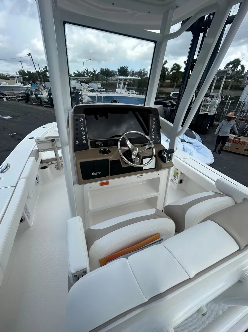 Slide: The Image of 2025 Robalo 246 Cayman boat interior with steering console and seating. - 5