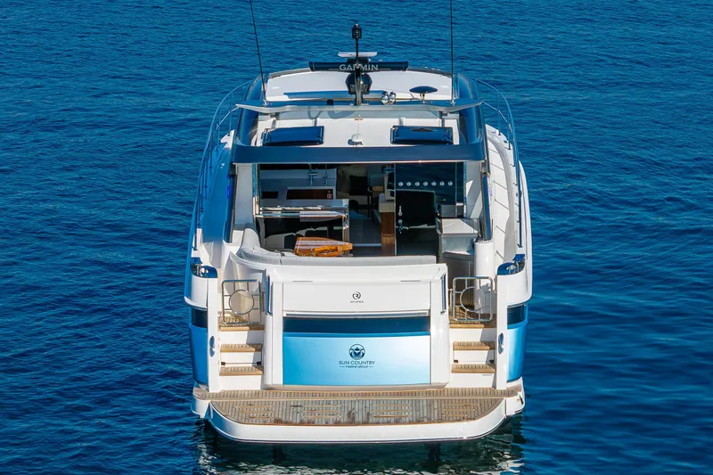 Slide: The Image of 2025 Riviera 4600 Sport Yacht on calm blue water, rear view. - 17