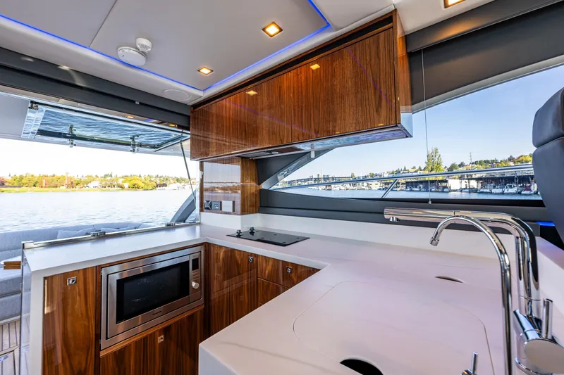 Slide: The Image of Luxurious kitchen interior of 2025 Riviera 4600 Sport Yacht with modern appliances and scenic water view. - 24